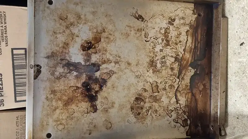 Commercial oven before laser cleaning - covered in carbonized grease and baked-on residue